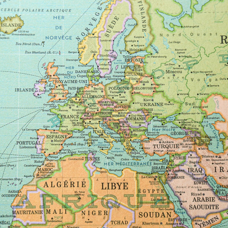K&ouml;nnte beinhalten: Eine Vintage-Weltkarte mit hellblauem Hintergrund und gr&uuml;nen, gelben und braunen R&auml;ndern. Die Karte zeigt die Kontinente Europa, Afrika und Asien. Die Karte ist mit den Namen von L&auml;ndern und St&auml;dten beschriftet.