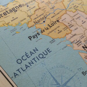 May include: A vintage map of France with the region "Pays de la Loire" highlighted in yellow. The map shows the Atlantic Ocean, the cities of Nantes, La Roche-sur-Yon, and La Rochelle, and the compass rose.