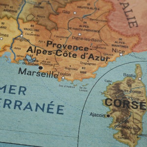 May include: A vintage map of France with the regions of Provence-Alpes-C&ocirc;te d'Azur and Corsica highlighted. The map shows major cities like Marseille, Nice, and Ajaccio.