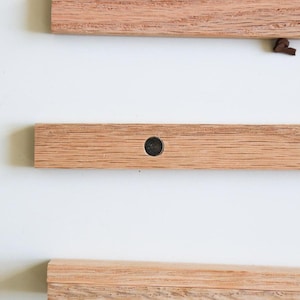 K&ouml;nnte beinhalten: Nahaufnahme einer Holzregal mit einer schwarzen Metallschraube in der Mitte.