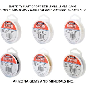 May include: Five spools of Beadalon Elasticity elastic cord in different colors: clear, black, satin rose gold, satin gold, and satin silver. Each spool is labeled with the cord size in inches and millimeters, as well as the length in feet and meters.