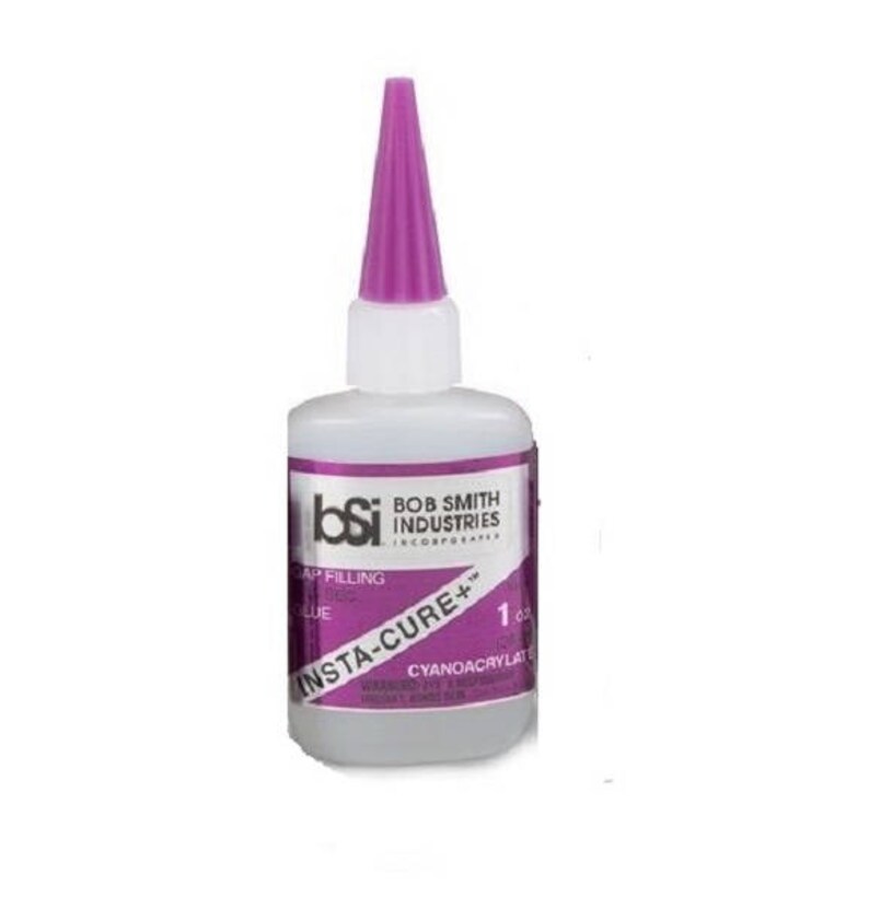 May include: A clear plastic bottle of Insta-Cure+ gap filling glue from Bob Smith Industries. The bottle has a purple cap and a label with the company logo and product information.