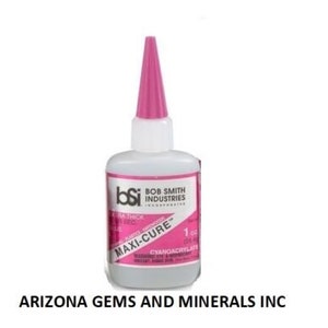 May include: A pink bottle of Bob Smith Industries Maxi-Cure Extra Thick cyanoacrylate adhesive. The bottle is labeled with the brand name, product name, and size: 1 oz (29.5 ml).