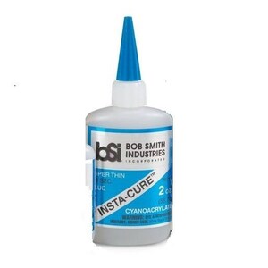 May include: A blue bottle of Bob Smith Industries Insta-Cure super thin cyanoacrylate glue. The bottle is labeled with the text "Insta-Cure" and "2 oz (56 g)".