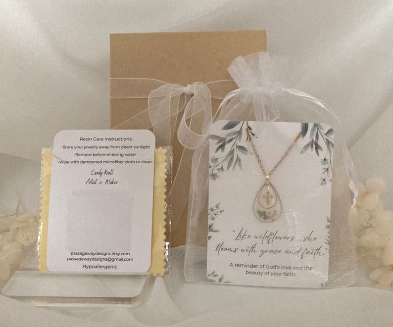 Pu&ograve; includere: Una collana color oro con un ciondolo a forma di goccia contenente fiori secchi, presentata con una confezione regalo e una carta con la scritta "like wildflowers, she blooms with grace and faith." Include anche un panno per la pulizia e le istruzioni per la cura.