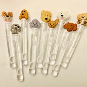 May include: A set of ten clear plastic bubble wands with various dog-shaped toppers. The toppers are made of fabric and feature different dog breeds, including a poodle, a chihuahua, a golden retriever, and a bloodhound.