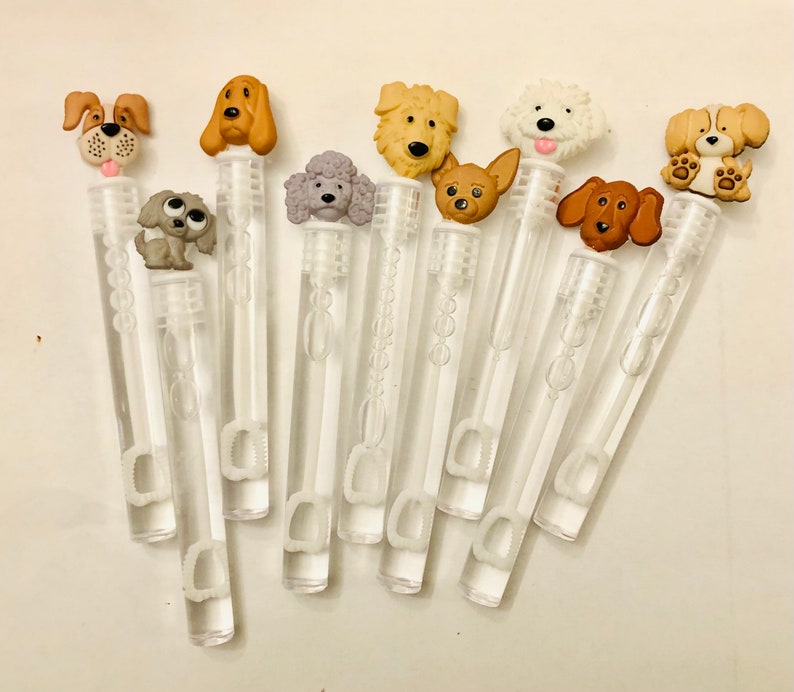 May include: A set of ten clear plastic bubble wands with various dog-shaped toppers. The toppers are made of fabric and feature different dog breeds, including a poodle, a chihuahua, a golden retriever, and a bloodhound.