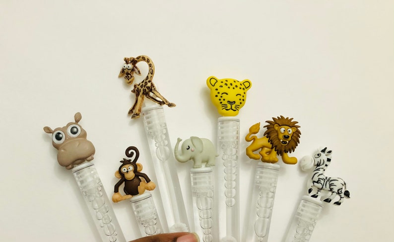May include: Set of six clear plastic bubble wands with animal-shaped tops. The animals include a giraffe, leopard, lion, elephant, monkey, and zebra. The wands are approximately 6 inches long.