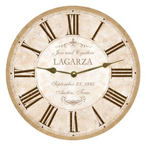 May include: A vintage-style clock face with Roman numerals and a gold-colored hour and minute hand. The clock face is cream-colored with a distressed look. The text "Jose and Cynthia LAGARZA September 23, 1995 Austin, Texas" is printed on the clock face.