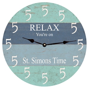 May include: A round wooden clock with a blue and green striped design. The clock face has white numbers and the text "RELAX You're on St. Simons Time".
