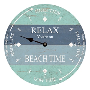 May include: A round wooden tide clock with a blue and green color scheme. The clock face has a white pointer and the text "HIGH TIDE", "LOW TIDE", "RISING TIDE", "FALLING TIDE", "RELAX You're on", and "BEACH TIME".
