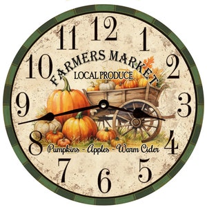Könnte beinhalten: Eine runde Uhr im Vintage-Stil mit grünem Rand und römischen Ziffern. Das Zifferblatt zeigt ein gemaltes Bild eines Holzkarrens voller Kürbisse und den Text "Farmers Market Local Produce". Der Text "Pumpkins - Apples - Warm Cider" steht unter dem Wagen.