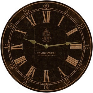 May include: A round, black clock face with Roman numeral markings and gold-colored hands. The clock face has a distressed, aged look and features the text "CAMBERWELL ENGLAND" and a crest with the text "ALLS WELL".