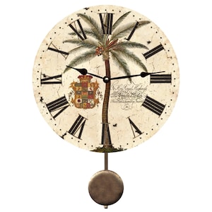 May include: A white pendulum clock with a distressed finish features a palm tree and a coat of arms. The clock face has Roman numerals and a black pendulum. The clock face also includes the text "For His Royal Highness The Prince of Wales This Plate is humbly Inscrib'd No. 1."