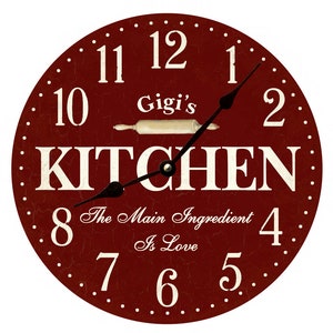 May include: Red round kitchen clock with white numbers and a rolling pin graphic. The clock face reads "Gigi's Kitchen" and "The Main Ingredient Is Love".