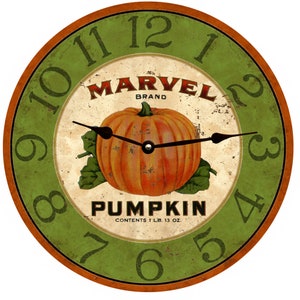 Op de afbeelding: Een ronde groene en oranje klok met Romeinse cijfers en een pompoenafbeelding. De wijzerplaat van de klok zegt "MARVEL BRAND PUMPKIN CONTENTS 1 LB. 13 OZ."