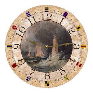 May include: A round, cream-colored clock with nautical signal flags around the edge. The clock face features a painting of a lighthouse and a ship on the water. The clock face has Roman numerals and a gold-colored hour and minute hand.