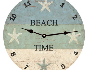 May include: A round wooden clock with a blue, green and white striped design. The clock face features white and blue starfish, black hands and black numbers. The clock face also has the text "BEACH TIME" in black.