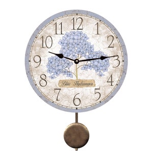 May include: A blue and white pendulum clock with a hydrangea design and the text "Blue Hydrangea".