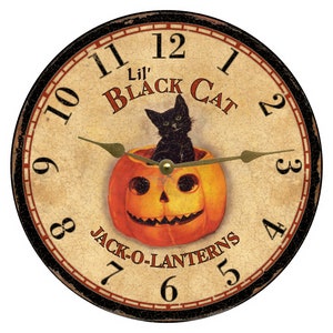 Op de afbeelding: Een ronde klok in vintage stijl met een zwarte kat die in een jack-o'-lantern zit. De wijzerplaat van de klok heeft Romeinse cijfers en de tekst "Lil' BLACK CAT JACK-O-LANTERNS".