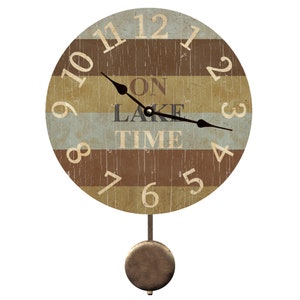 May include: A round wooden clock with a pendulum. The clock face has a striped design in brown, beige, and blue. The numbers are in black and the text says "On Lake Time".