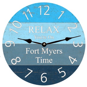 May include: A blue and white wooden clock with the text "RELAX You're On Fort Myers Time" and black hands.
