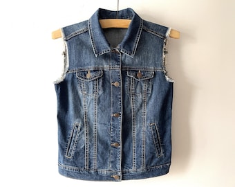 May include: A blue denim vest with a classic button-up front and frayed edges on the armholes.