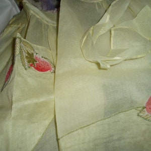 May include: A pair of sheer, pale yellow fabric panels with embroidered strawberry designs. The fabric is delicate and has a soft, flowing texture.