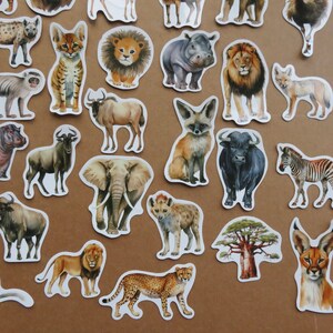 May include: A selection of animal stickers with watercolour illustrations of African wildlife. The stickers include a giraffe, lion, zebra, elephant, cheetah, and more. Each sticker has a white border and is set against a brown background.