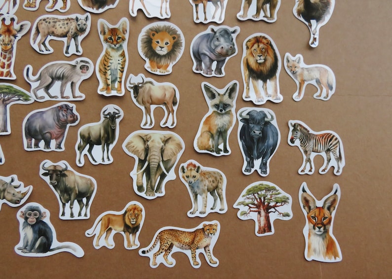 May include: A selection of animal stickers with watercolour illustrations of African wildlife. The stickers include a giraffe, lion, zebra, elephant, cheetah, and more. Each sticker has a white border and is set against a brown background.