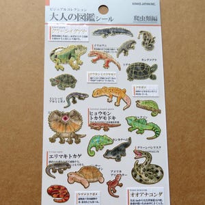 Puede incluir: Una hoja de pegatinas con temática de reptiles, con ilustraciones detalladas de iguanas, serpientes y tortugas. Las pegatinas son coloridas y tienen texto japonés.