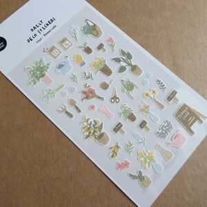 May include: A sheet of "Daily Deco Stickers" featuring various floral and gardening-themed illustrations. The stickers include potted plants, bouquets, gardening tools, and the text "Flower Cafe". The stickers are in soft pastel colors.