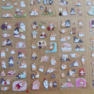 May include: Sheets of clear stickers featuring various cartoon rabbits in different poses and settings. The stickers showcase rabbits in various colors, including brown, white, and gray, with some stickers including text such as "OK" and "Hi!"