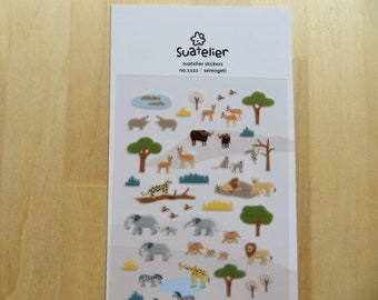 May include: Sheet of Suatelier stickers featuring various African animals and scenery. Includes elephants, lions, giraffes, zebras, and trees. The stickers are in a cartoon style with a white background and the text "Suatelier" and "serengeti".