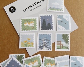 May include: A collection of "cereal stickers" featuring various park scenes. The stickers showcase illustrations of a cat, flowers, a lake, trees, and a bench. The text "cereal stickers" and "307 from the park" are visible on the packaging.