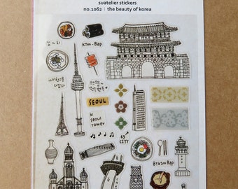 May include: Clear sticker sheet featuring various black and white illustrations of Korean landmarks and food. Includes images of a tower, gate, church, and dishes like Kim-Bap and Bibim Bap. The text "Suatelier" and "the beauty of korea" are also visible.