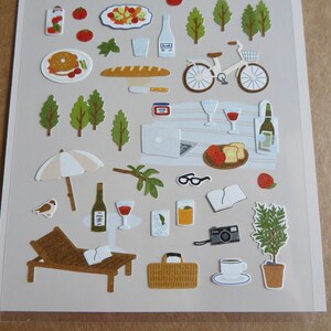 K&ouml;nnte beinhalten: Ein Stickerbogen mit Illustrationen von Picknick- und Freizeitartikeln. Enth&auml;lt ein Fahrrad, Weinflaschen, Essen, B&auml;ume, eine Sonnenliege und eine Kamera. Die Aufkleber sind im Cartoon-Stil mit neutraler Farbpalette.