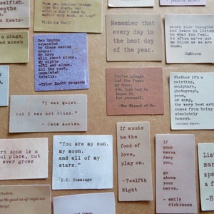May include: A collection of small, rectangular cards with quotes printed in a typewriter font. The cards are in various colors, including beige, brown, and white. The quotes are from famous authors and poets.