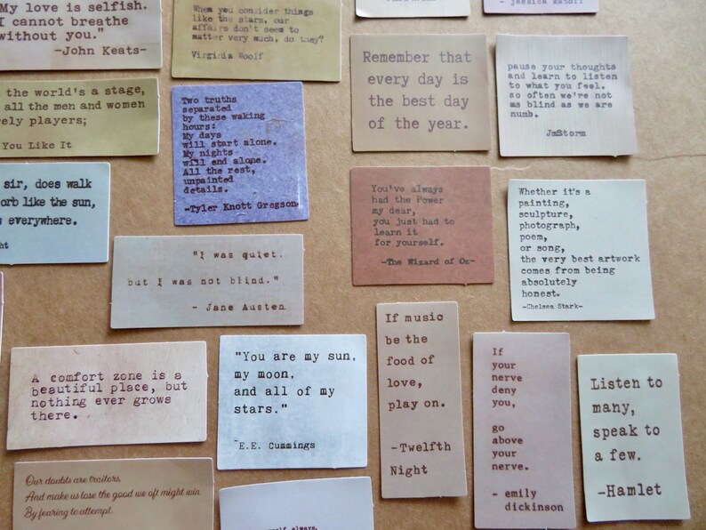 May include: A collection of small, rectangular cards with quotes printed in a typewriter font. The cards are in various colors, including beige, brown, and white. The quotes are from famous authors and poets.