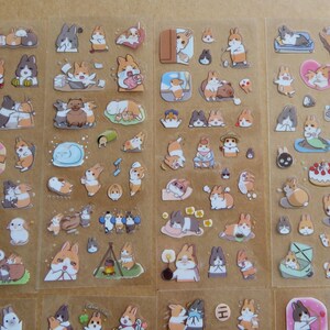 May include: Sheets of stickers featuring various cartoon rabbits in different poses and settings. The stickers showcase rabbits in various activities, such as lounging, eating, and wearing outfits. The stickers are in shades of brown, white, and orange.