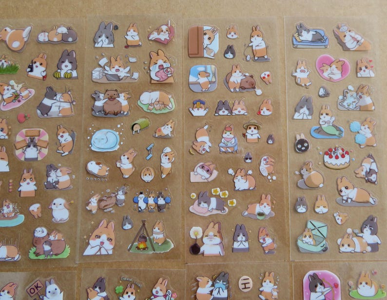 May include: Sheets of stickers featuring various cartoon rabbits in different poses and settings. The stickers showcase rabbits in various activities, such as lounging, eating, and wearing outfits. The stickers are in shades of brown, white, and orange.