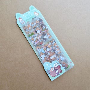 May include: A package of stickers featuring various cartoon animals, primarily dogs and rabbits, in a variety of poses and colors. The package is light green with the text "PET PLANET" and a cartoon illustration of animals.