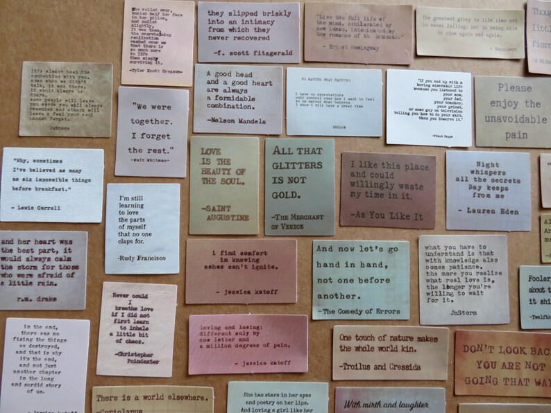 May include: A collection of small, rectangular cards with quotes printed in black ink. The cards are in various colors, including beige, pink, and green. The quotes are from famous authors and philosophers.