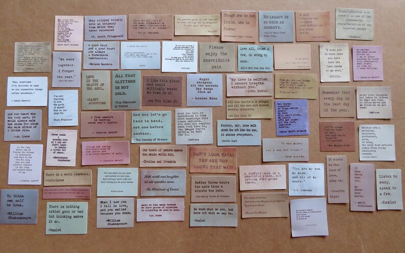 May include: A collection of vintage-style quote cards in various colors, including beige, pink, and green. Each card features a quote in a classic serif font. The cards are arranged on a neutral surface, creating a visually appealing display.