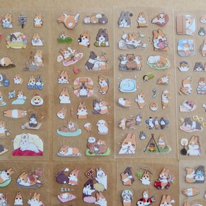 May include: Sheets of stickers featuring various cartoon rabbits in different poses and settings. The stickers include rabbits with orange, white, and gray fur, some with accessories. The word "GOOD" is visible on one sticker.