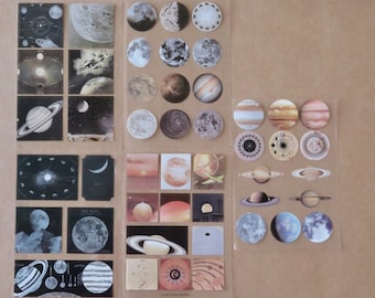 Puede incluir: Una colección de pegatinas con temática espacial que representan planetas, lunas y cuerpos celestes. Las pegatinas tienen varios tamaños y formas, con ilustraciones detalladas de Saturno, Júpiter y la luna. La paleta de colores incluye tonos de marrón, beige y blanco.