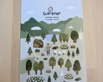 May include: Sheet of Suatelier forest stickers featuring a variety of forest-themed illustrations. Includes trees, a house, a person with an axe, flowers, and a rabbit. The background has a mountain and sky design.