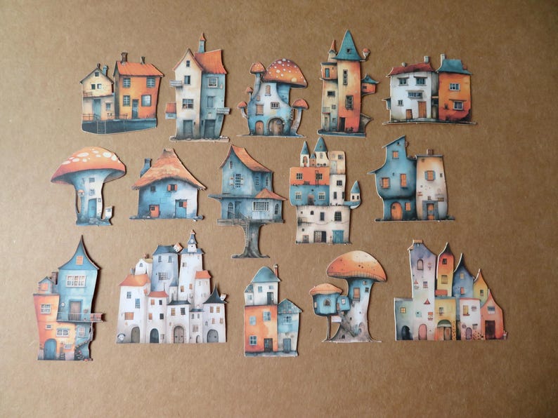 May include: A collection of whimsical, colorful paper cutouts of houses and mushroom-shaped dwellings. The houses feature orange, blue, and white facades with various architectural styles. The cutouts are arranged on a brown surface.