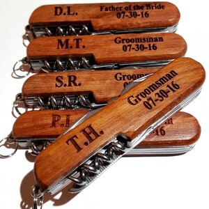 May include: Five wooden handled pocket knives with engraved initials and dates. The knives have a silver blade and a corkscrew.