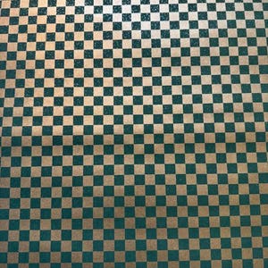 May include: A close-up shot of a checkered pattern. The pattern consists of alternating squares of teal and gold. The squares are evenly sized and arranged in a grid, creating a classic checkerboard design. The overall effect is a visually appealing and symmetrical pattern.